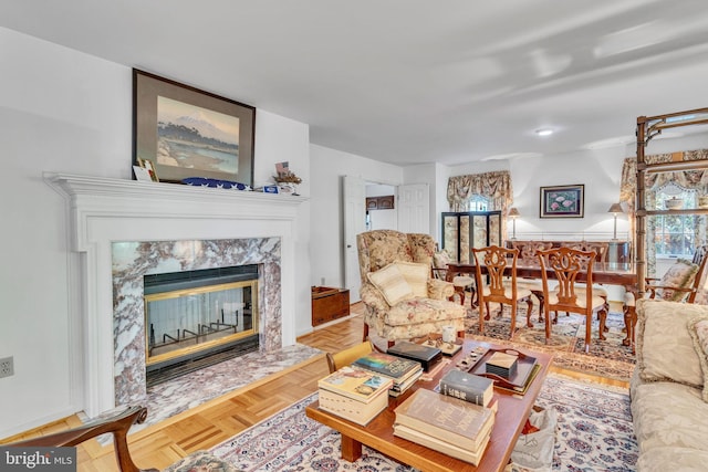 living room with a premium fireplace, plenty of natural light, and light parquet flooring