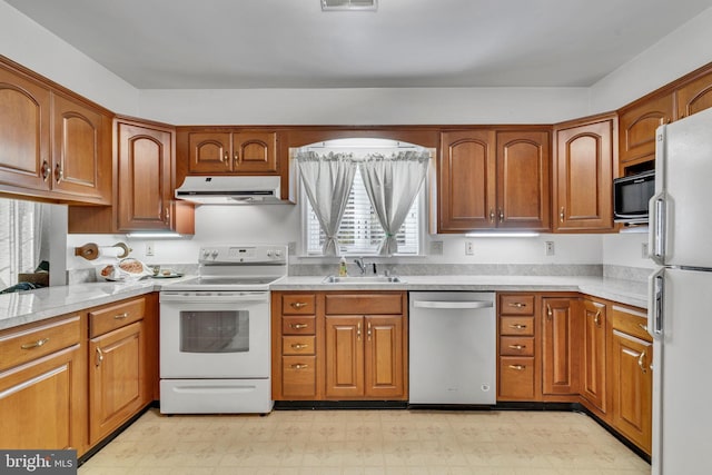 11160 Cove Lake Rd, Lusby, MD 20657 - kitchen featuring white appliances, light countertops, under cabinet range hood, light floors, and a sink