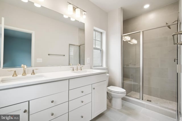 bathroom featuring tile patterned flooring, a shower with shower door, vanity, and toilet