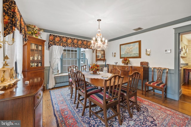 dining room featuring ornamental molding, a chandelier, and wood-type flooring