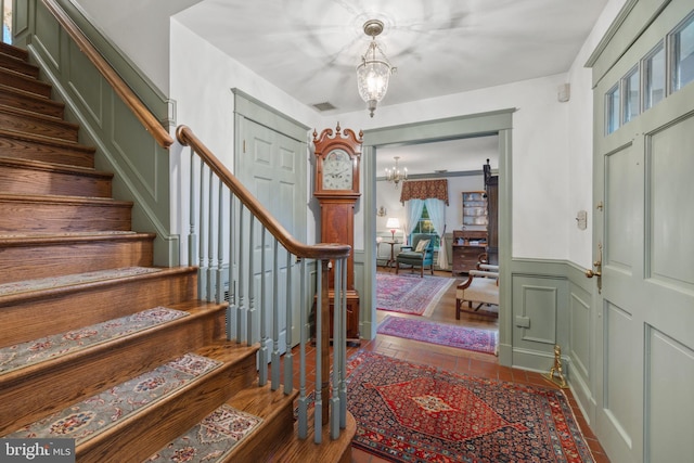 entryway featuring an inviting chandelier, a barn door, and dark hardwood / wood-style flooring