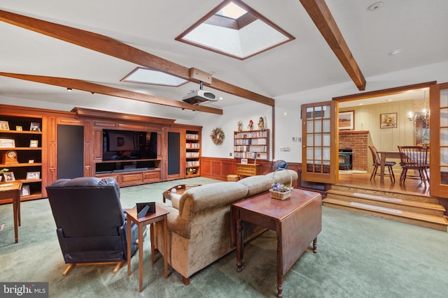 living room with a brick fireplace, carpet floors, and lofted ceiling with skylight