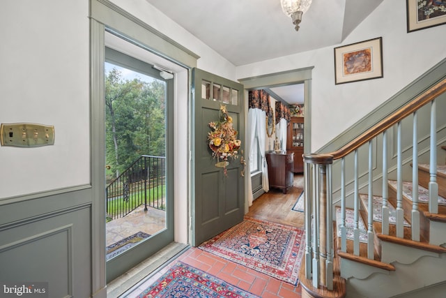 foyer entrance with lofted ceiling and hardwood / wood-style floors