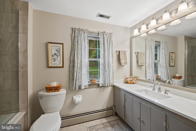 bathroom with a tile shower, vanity, a baseboard radiator, and toilet