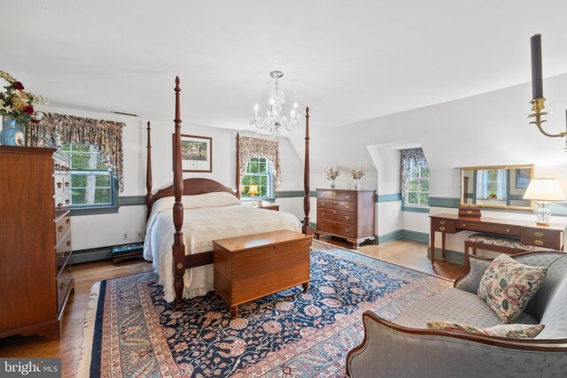 bedroom with a notable chandelier and light hardwood / wood-style floors