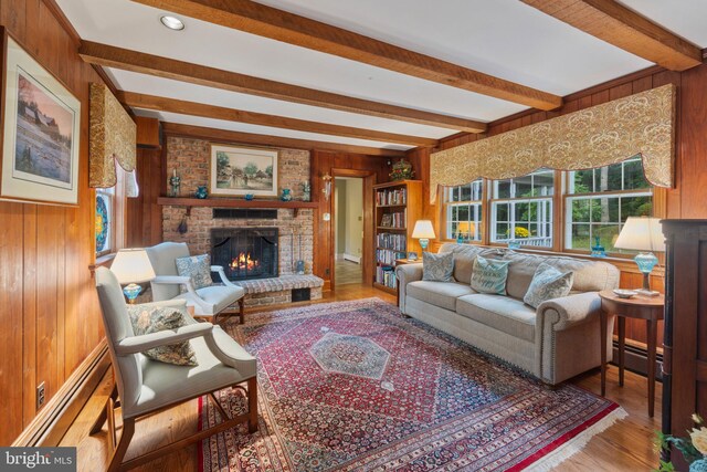 living room featuring a fireplace, beamed ceiling, hardwood / wood-style flooring, and wooden walls