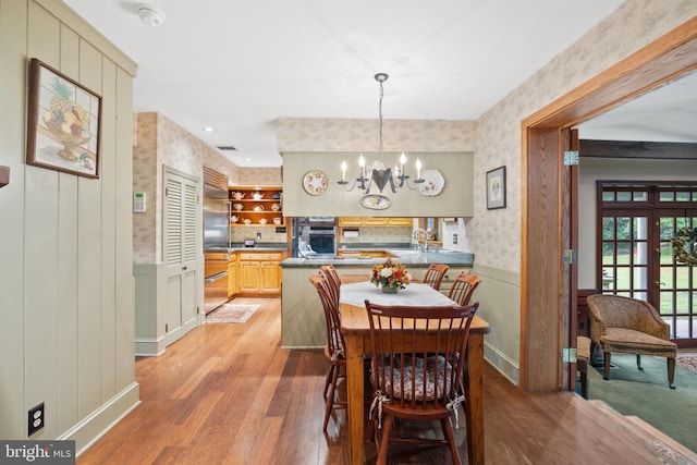 dining area with an inviting chandelier and light hardwood / wood-style flooring