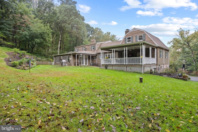 back of property featuring a yard and a sunroom