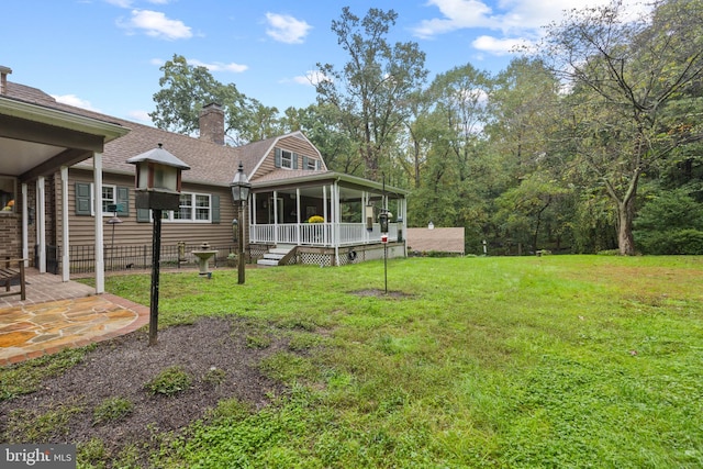 view of yard featuring a sunroom and a patio