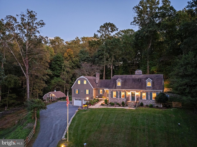 cape cod home with a garage and a lawn