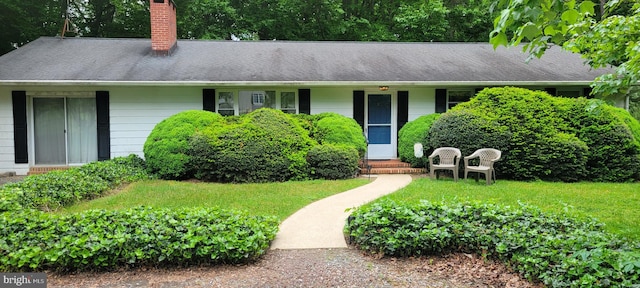 single story home featuring a front lawn