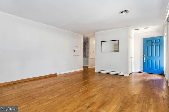 foyer with crown molding, wood-type flooring, and a baseboard heating unit