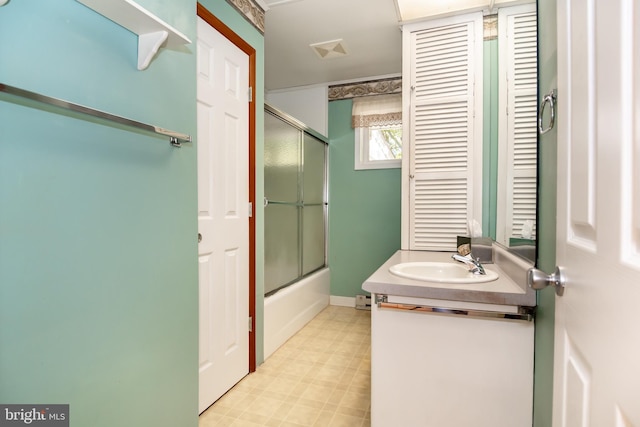 bathroom with vanity and bath / shower combo with glass door