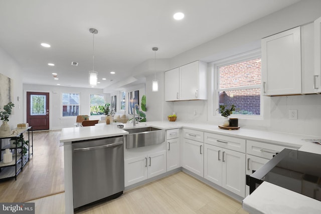 kitchen with dishwasher, sink, hanging light fixtures, kitchen peninsula, and white cabinetry