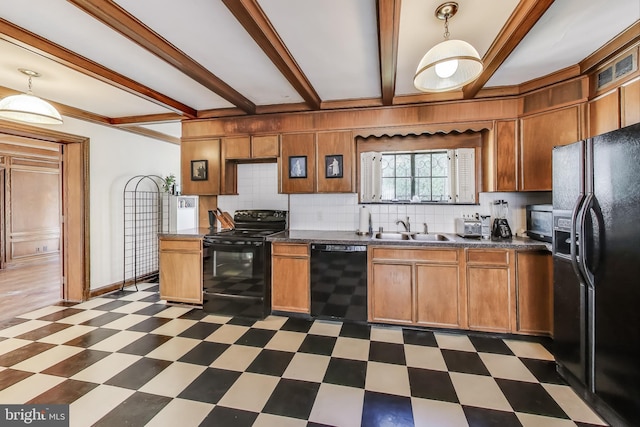 kitchen with a sink, black appliances, dark countertops, beamed ceiling, and dark floors