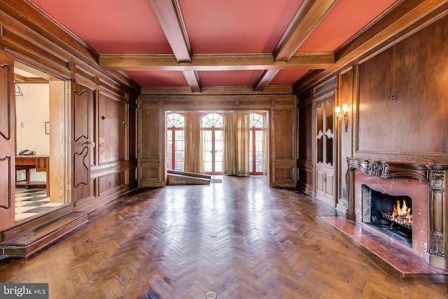 unfurnished living room featuring beamed ceiling, a premium fireplace, wood walls, and a decorative wall