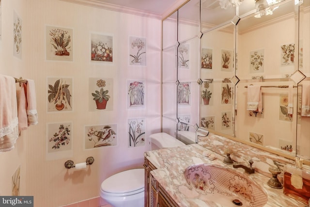 bathroom with vanity, crown molding, and toilet