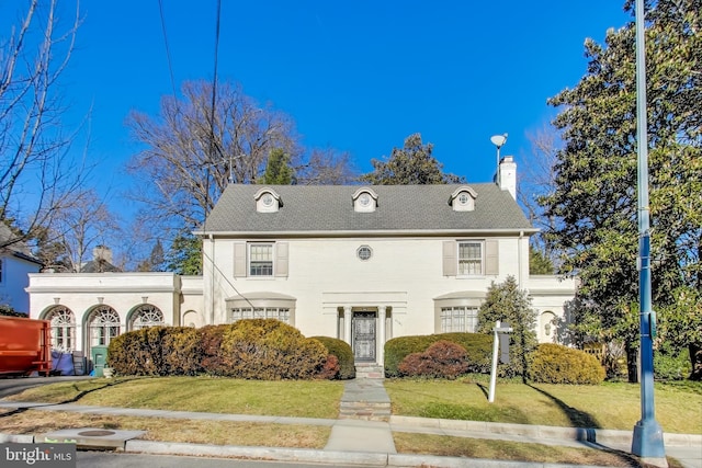 view of front of house featuring a chimney and a front yard