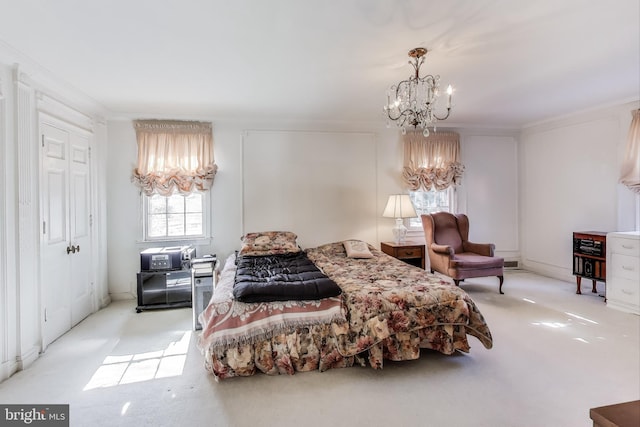 bedroom with an inviting chandelier, carpet flooring, and crown molding