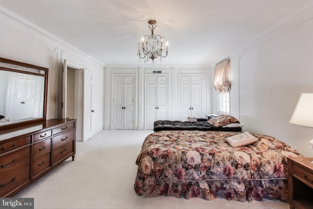 bedroom featuring light carpet, a notable chandelier, two closets, and crown molding