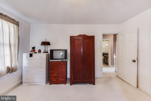 bedroom featuring baseboards and light carpet