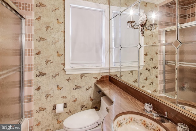 bathroom featuring wallpapered walls, toilet, and a sink