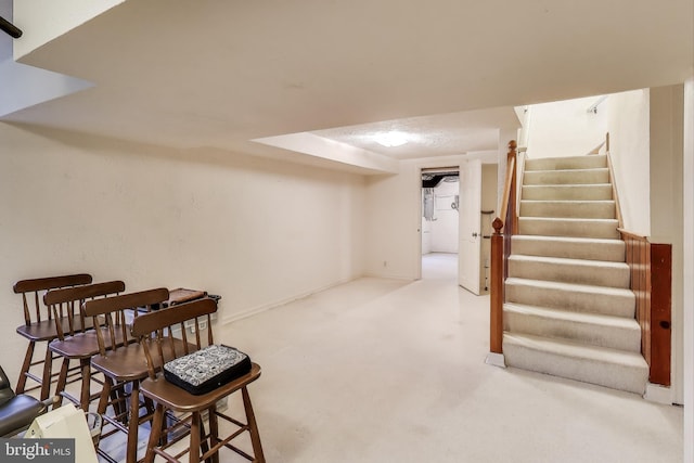 finished below grade area featuring stairway, carpet, and baseboards