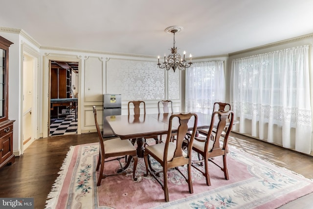 dining space featuring a chandelier, dark wood-type flooring, and ornamental molding