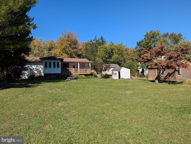 view of yard featuring a shed, a deck, and an outbuilding