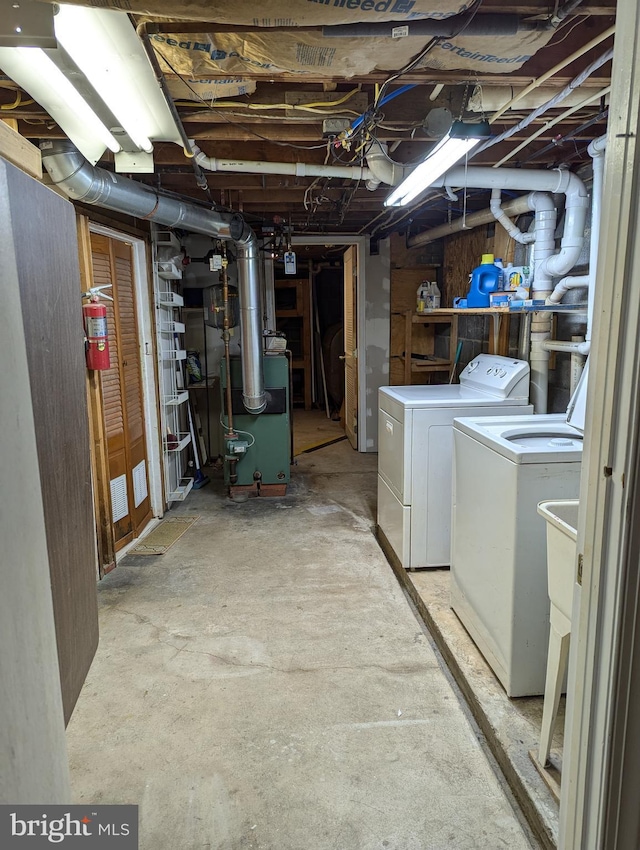 unfinished basement featuring a heating unit and washing machine and clothes dryer