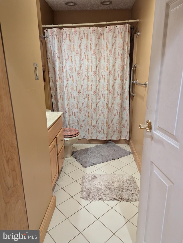 bathroom with tile patterned floors, vanity, a shower with curtain, and toilet