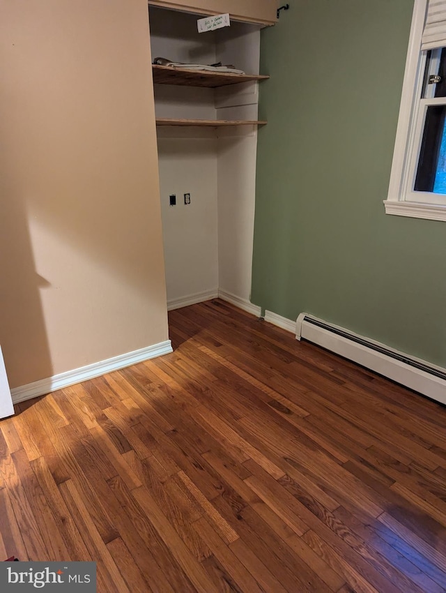 washroom featuring baseboards, a baseboard radiator, and wood finished floors