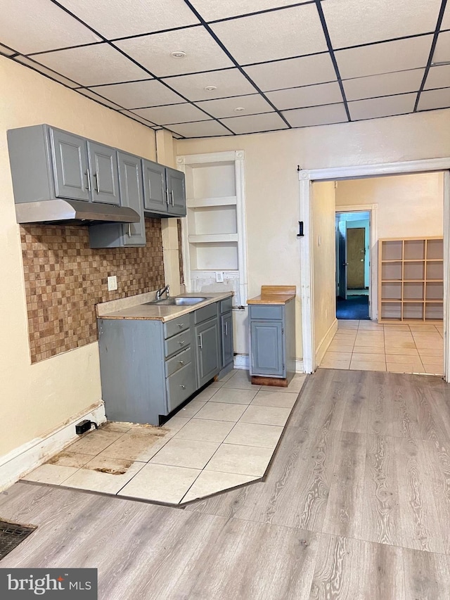 kitchen with decorative backsplash, light tile patterned floors, built in features, and gray cabinets