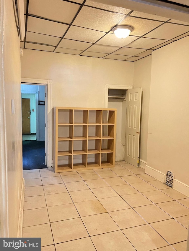 tiled spare room with a drop ceiling