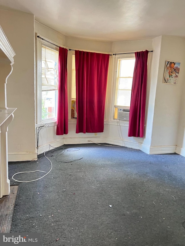 unfurnished living room featuring cooling unit and plenty of natural light