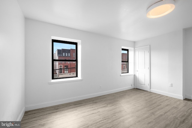 spare room with light wood-type flooring and plenty of natural light