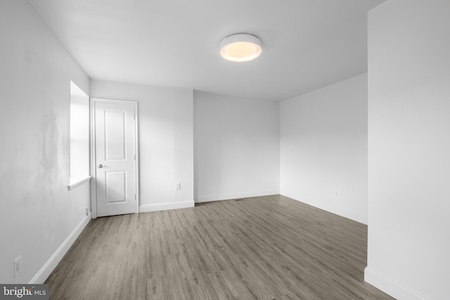 unfurnished room with wood-type flooring