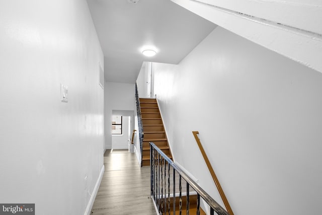 staircase featuring hardwood / wood-style flooring and vaulted ceiling