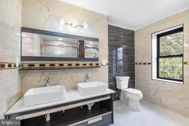 bathroom with tile walls, vanity, and toilet