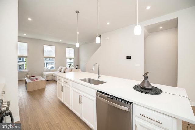 kitchen featuring pendant lighting, dishwasher, sink, light hardwood / wood-style flooring, and a center island with sink