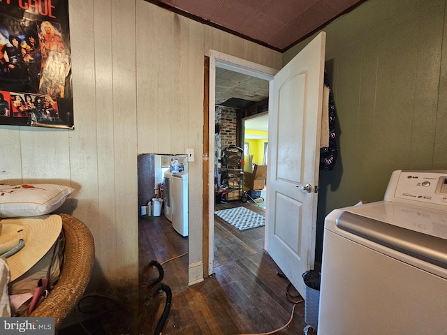 laundry room with wood walls, dark hardwood / wood-style floors, and washer / clothes dryer