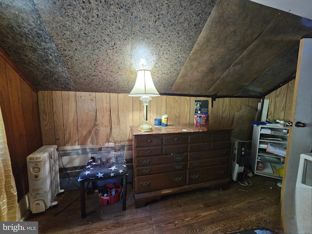 bonus room with wood walls, vaulted ceiling, and dark hardwood / wood-style floors