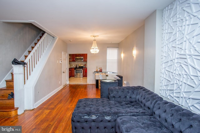 living room with a notable chandelier and dark wood-type flooring