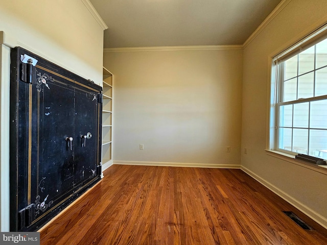 spare room with wood-type flooring and crown molding