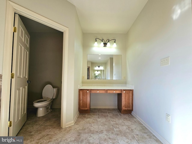 bathroom with tile patterned flooring, vanity, and toilet