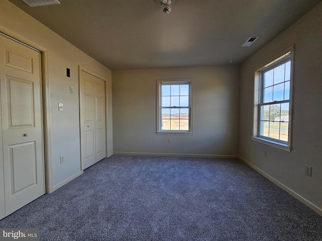 unfurnished bedroom featuring dark carpet