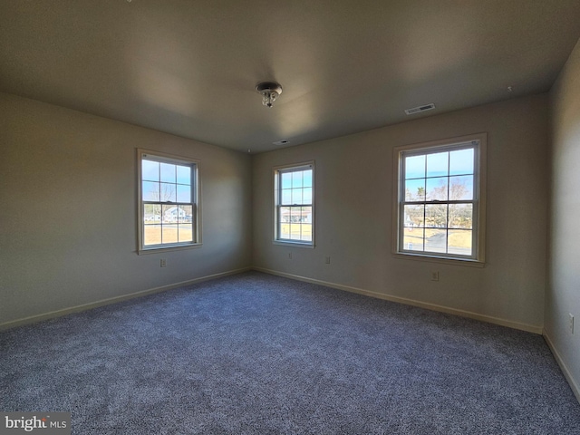 spare room with dark carpet