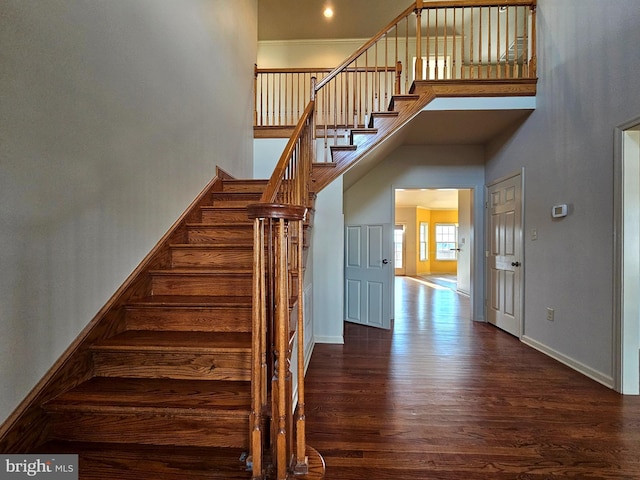 stairs featuring a high ceiling and wood-type flooring