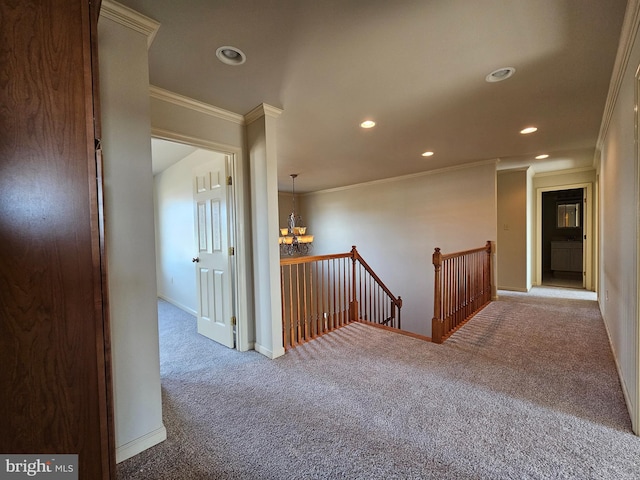 hall with crown molding, carpet, and a notable chandelier