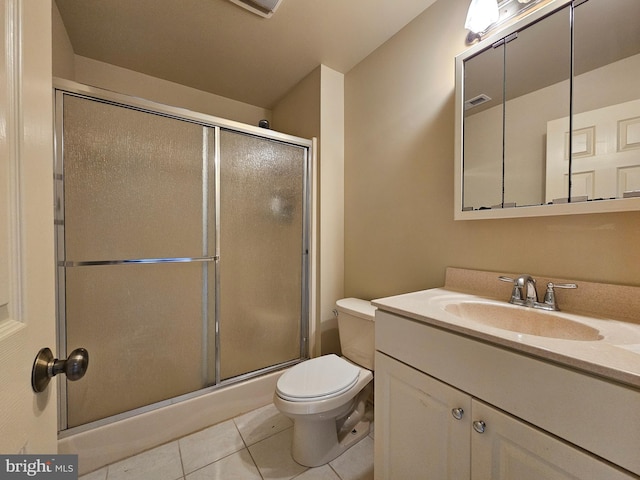 bathroom featuring tile patterned flooring, vanity, toilet, and walk in shower